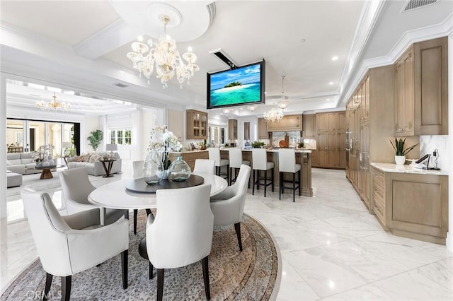 dining room with a tray ceiling, ornamental molding, and a chandelier