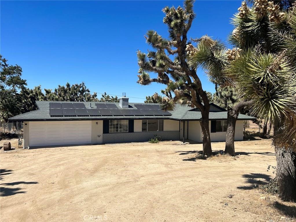 view of front of property with solar panels and a garage