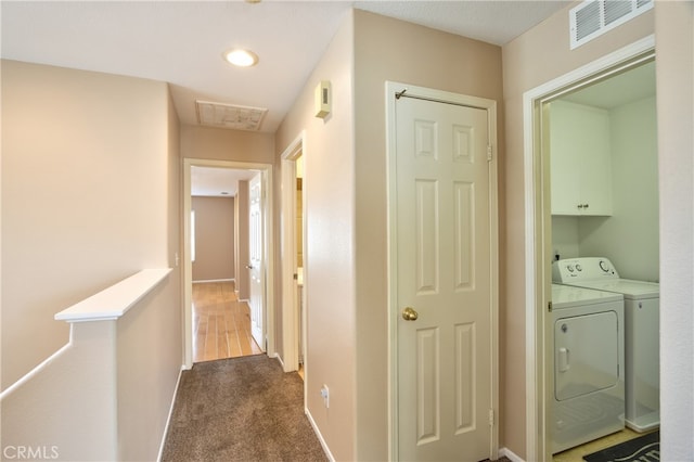 clothes washing area featuring cabinets, dark colored carpet, and washing machine and clothes dryer