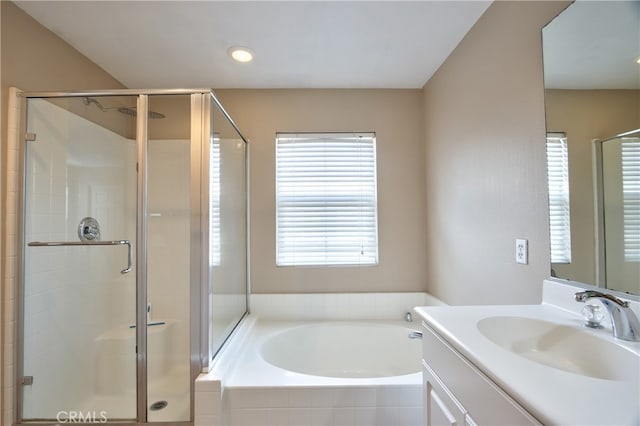 bathroom with vanity and shower with separate bathtub