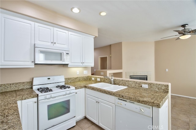 kitchen with kitchen peninsula, sink, and white appliances