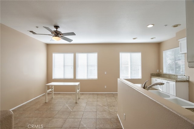 kitchen with ceiling fan, light tile patterned floors, a wealth of natural light, and white cabinetry