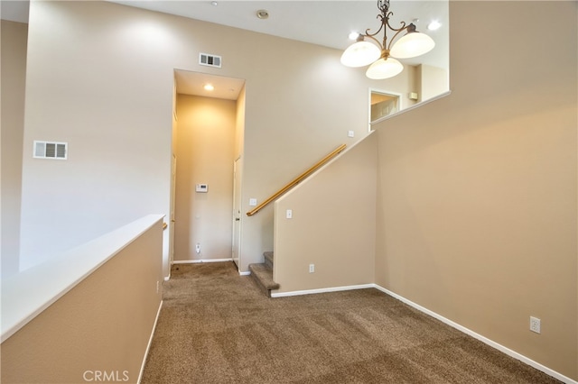 interior space featuring carpet, a towering ceiling, and a notable chandelier