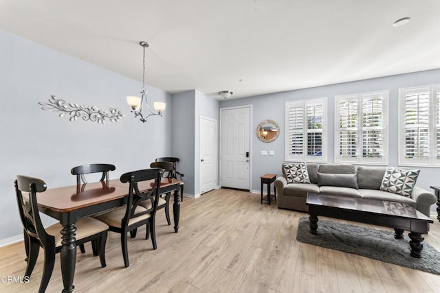 living room with an inviting chandelier and light wood-type flooring