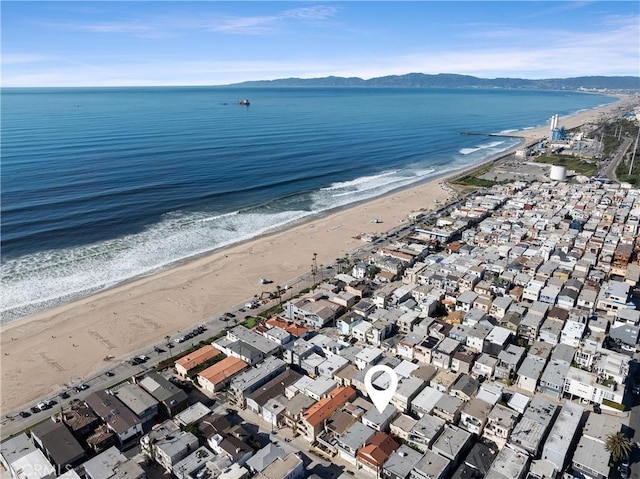 drone / aerial view featuring a view of the beach and a water and mountain view