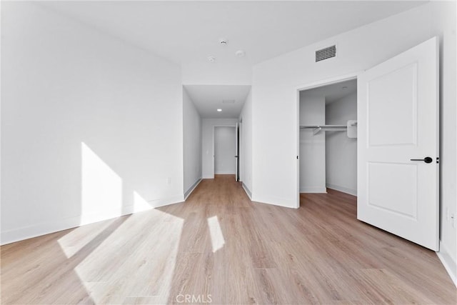 unfurnished bedroom with a closet and light hardwood / wood-style flooring