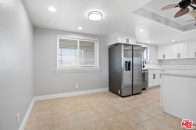 kitchen with light tile patterned floors, ceiling fan, appliances with stainless steel finishes, white cabinets, and sink