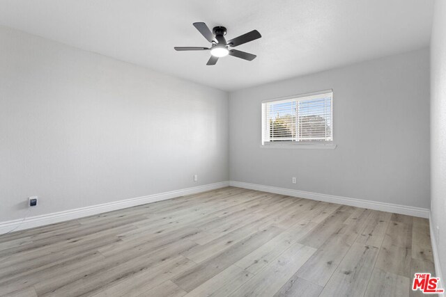 empty room with ceiling fan and light hardwood / wood-style floors