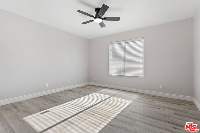 empty room with ceiling fan and light wood-type flooring