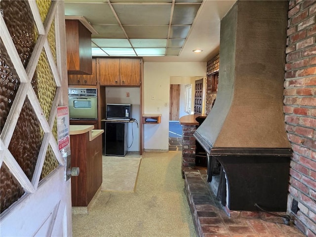 kitchen with black appliances and a drop ceiling