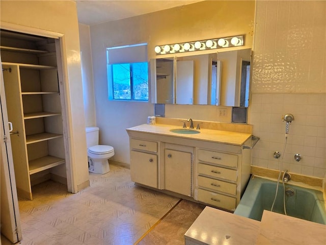 bathroom with toilet, a tub, and vanity