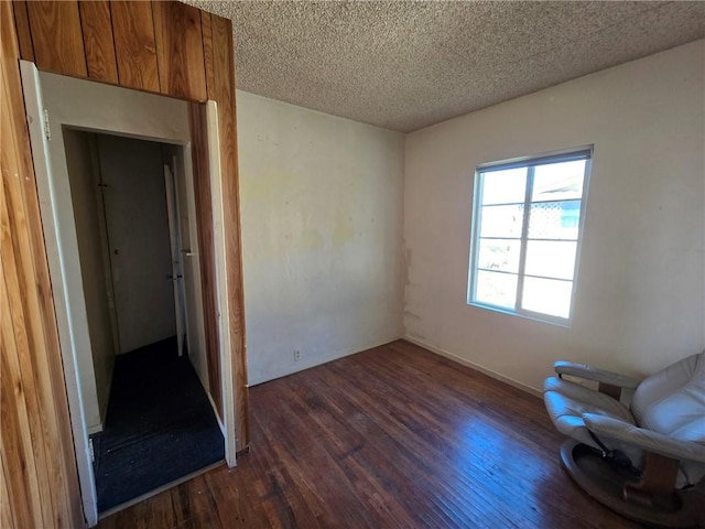 unfurnished room with dark hardwood / wood-style floors and a textured ceiling