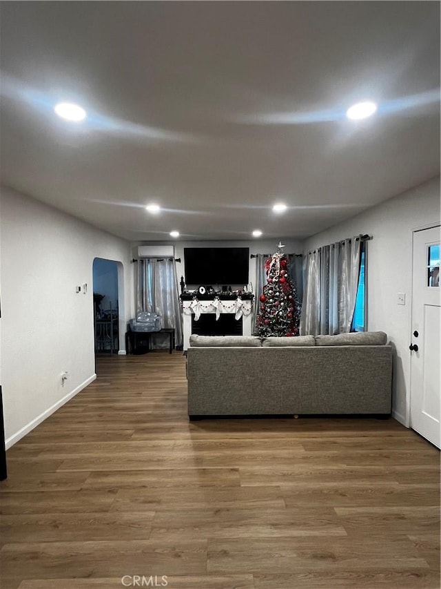 unfurnished living room featuring hardwood / wood-style flooring and a wall mounted AC