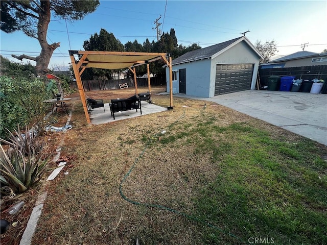 view of yard with a garage, a patio, and an outdoor structure