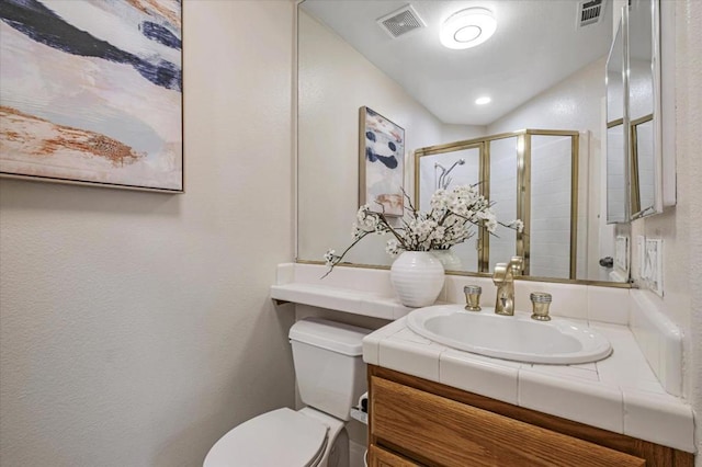 bathroom featuring walk in shower, vanity, and toilet