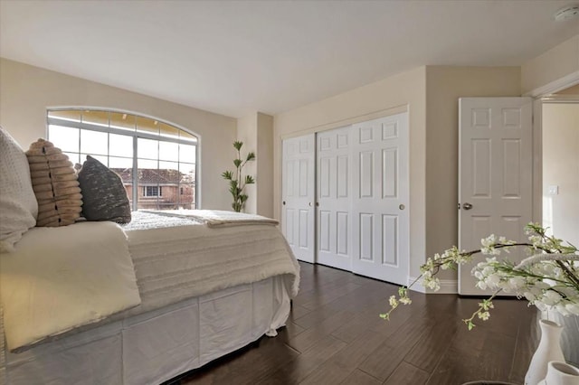 bedroom with dark hardwood / wood-style flooring and a closet