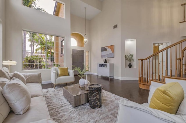 living room with a high ceiling and dark wood-type flooring