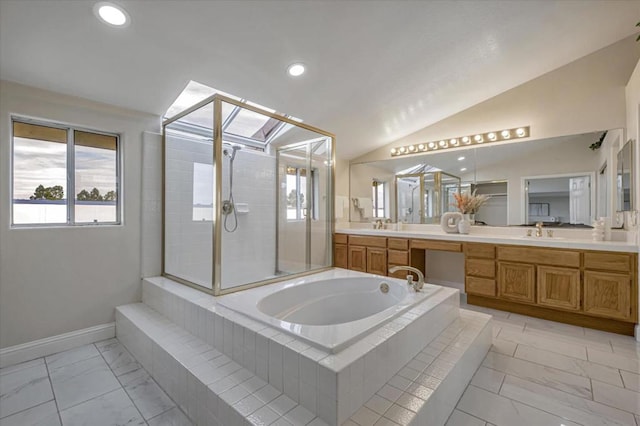 bathroom featuring plus walk in shower, vanity, and vaulted ceiling with skylight