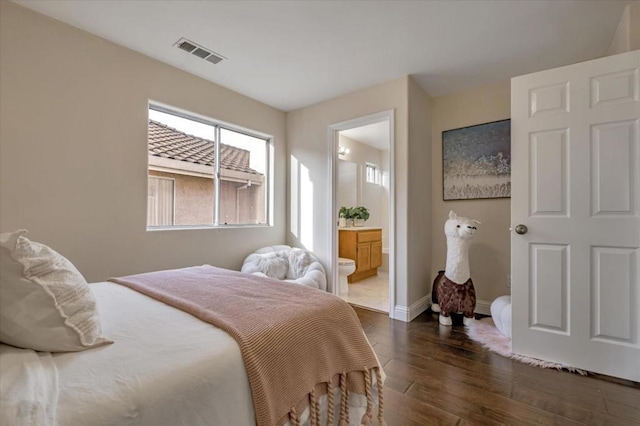 bedroom with ensuite bathroom and dark hardwood / wood-style flooring