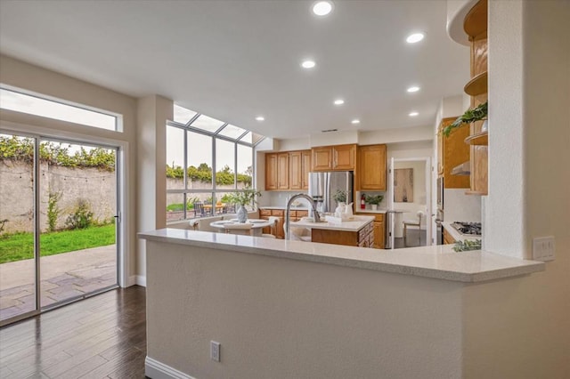 kitchen featuring a healthy amount of sunlight, stainless steel fridge, and kitchen peninsula