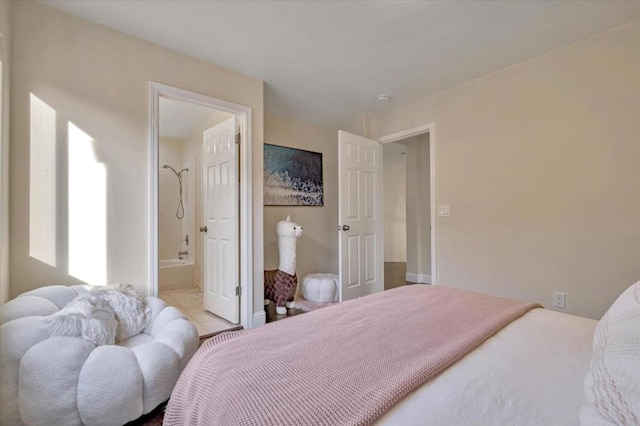 bedroom with ensuite bathroom and light tile patterned floors