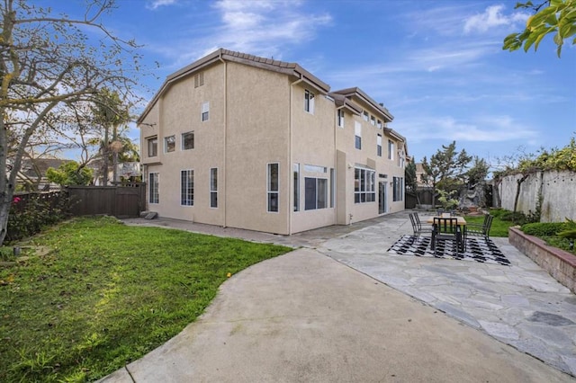 rear view of house with a yard and a patio