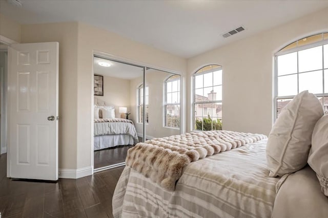 bedroom with a closet and dark wood-type flooring