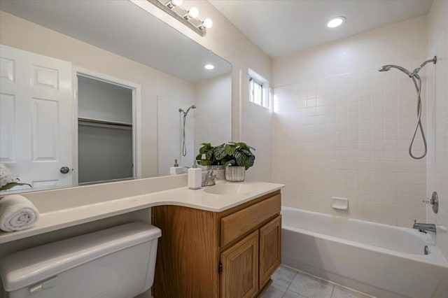 full bathroom featuring toilet, tile patterned flooring, tiled shower / bath, and vanity