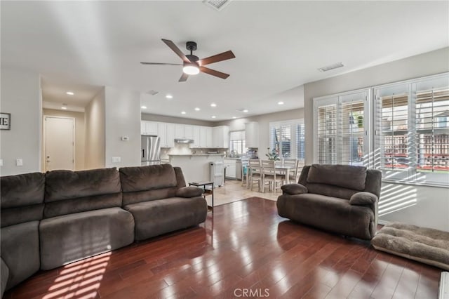 living room with ceiling fan and dark wood-type flooring