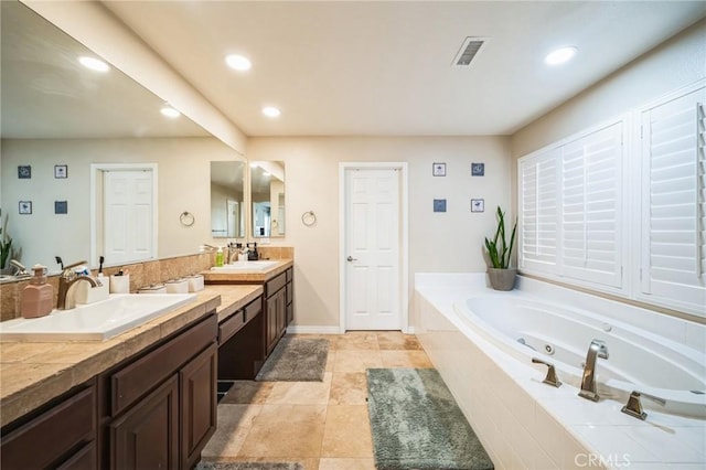 bathroom with a relaxing tiled tub and vanity