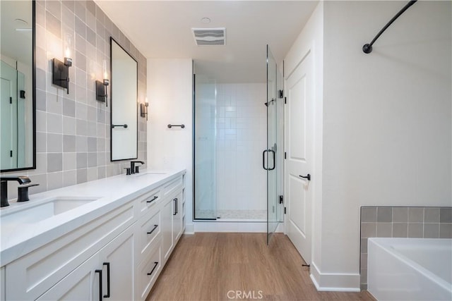 414 Main St Unit 310, Huntington Beach, CA 92647 - bathroom with wood finished floors, a shower stall, a bathtub, double vanity, and decorative backsplash