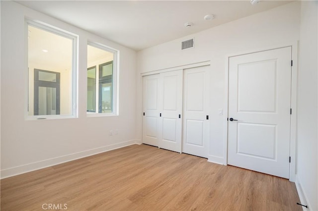 414 Main St Unit 310, Huntington Beach, CA 92647 - unfurnished bedroom featuring light wood finished floors, baseboards, and a closet