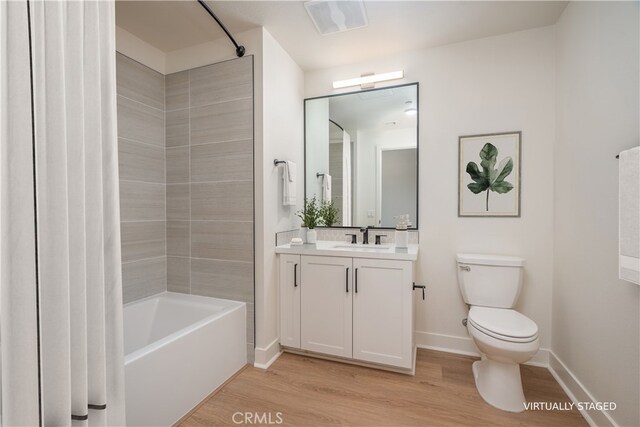 414 Main St Unit 310, Huntington Beach, CA 92647 - bathroom featuring wood finished floors, toilet, shower / tub combo with curtain, vanity, and baseboards