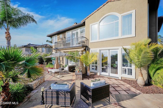 back of property with a balcony and a patio area