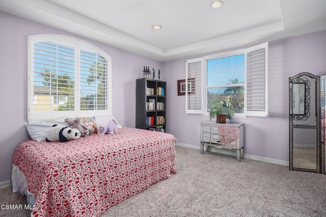 carpeted bedroom featuring a tray ceiling