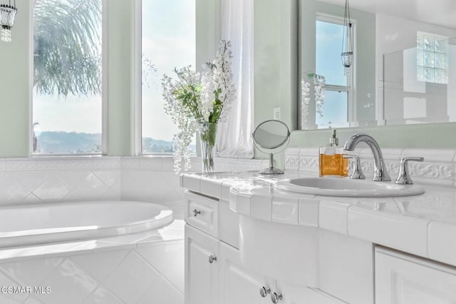 bathroom with a relaxing tiled tub and vanity