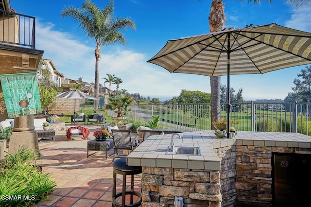 view of patio with area for grilling and an outdoor wet bar