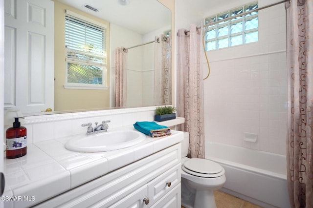 full bathroom with tile patterned flooring, shower / bath combination with curtain, vanity, and toilet