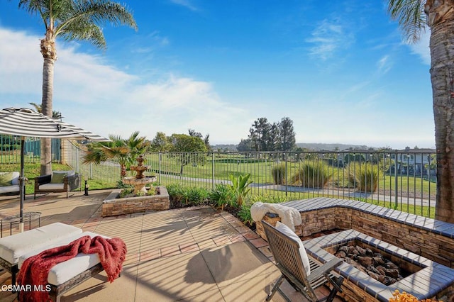 wooden deck featuring an outdoor fire pit and a patio area