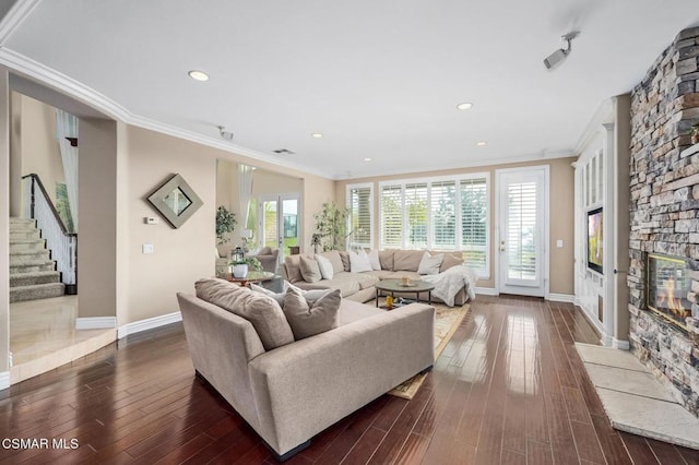 living room with dark hardwood / wood-style flooring, crown molding, and a fireplace