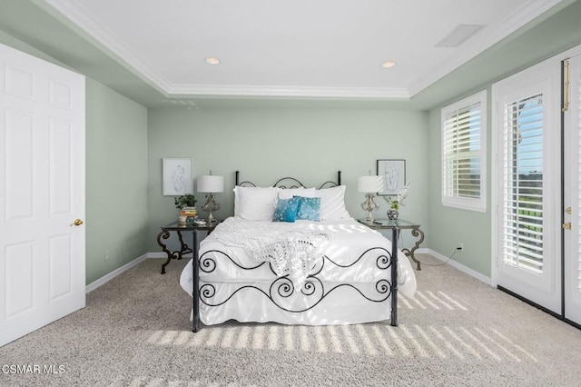 bedroom featuring ornamental molding, light carpet, and a raised ceiling