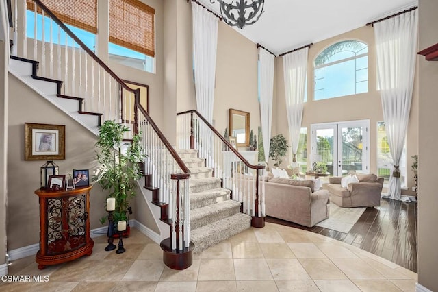 interior space with french doors, a towering ceiling, and tile patterned floors