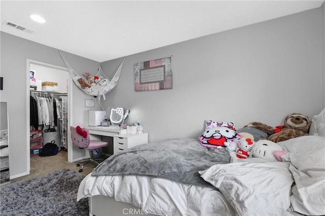 bedroom with a spacious closet, carpet floors, and a closet