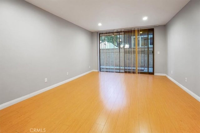 empty room with wood-type flooring and expansive windows