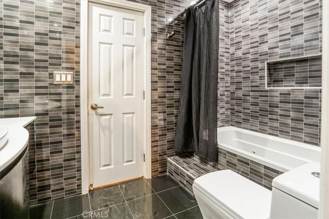 bathroom featuring shower / bath combo with shower curtain, toilet, tile patterned flooring, and tile walls