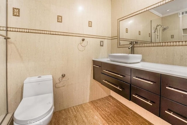 bathroom featuring crown molding, a shower, tile walls, toilet, and vanity