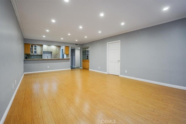 unfurnished living room with crown molding and light hardwood / wood-style flooring