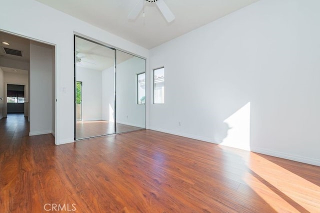 unfurnished bedroom featuring ceiling fan, hardwood / wood-style floors, and a closet