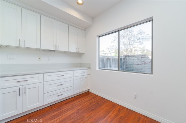 kitchen with hardwood / wood-style floors and white cabinets