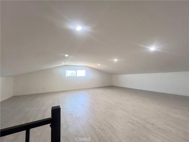 bonus room featuring vaulted ceiling and light wood-type flooring